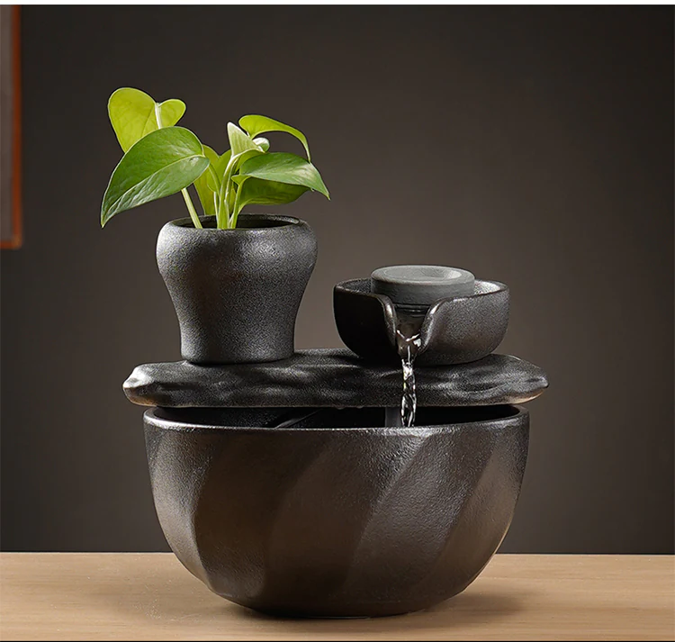 Ceramic fountain with visible flowing water against a dark neutral background